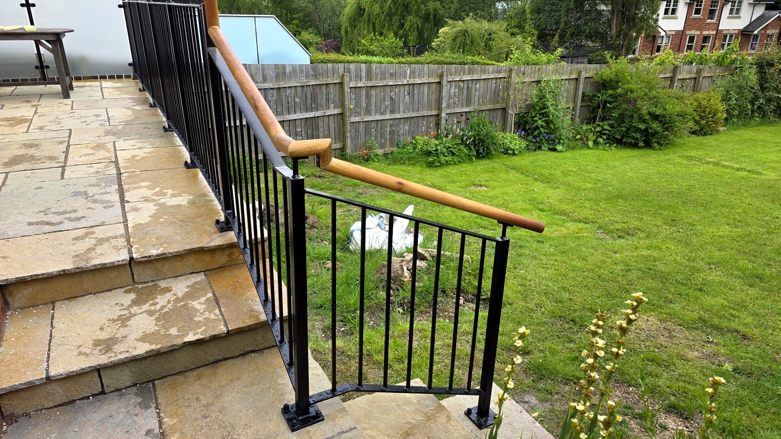 Satin black metal railing with oak timber handrail on a raised garden terrace, Bradway, Sheffield